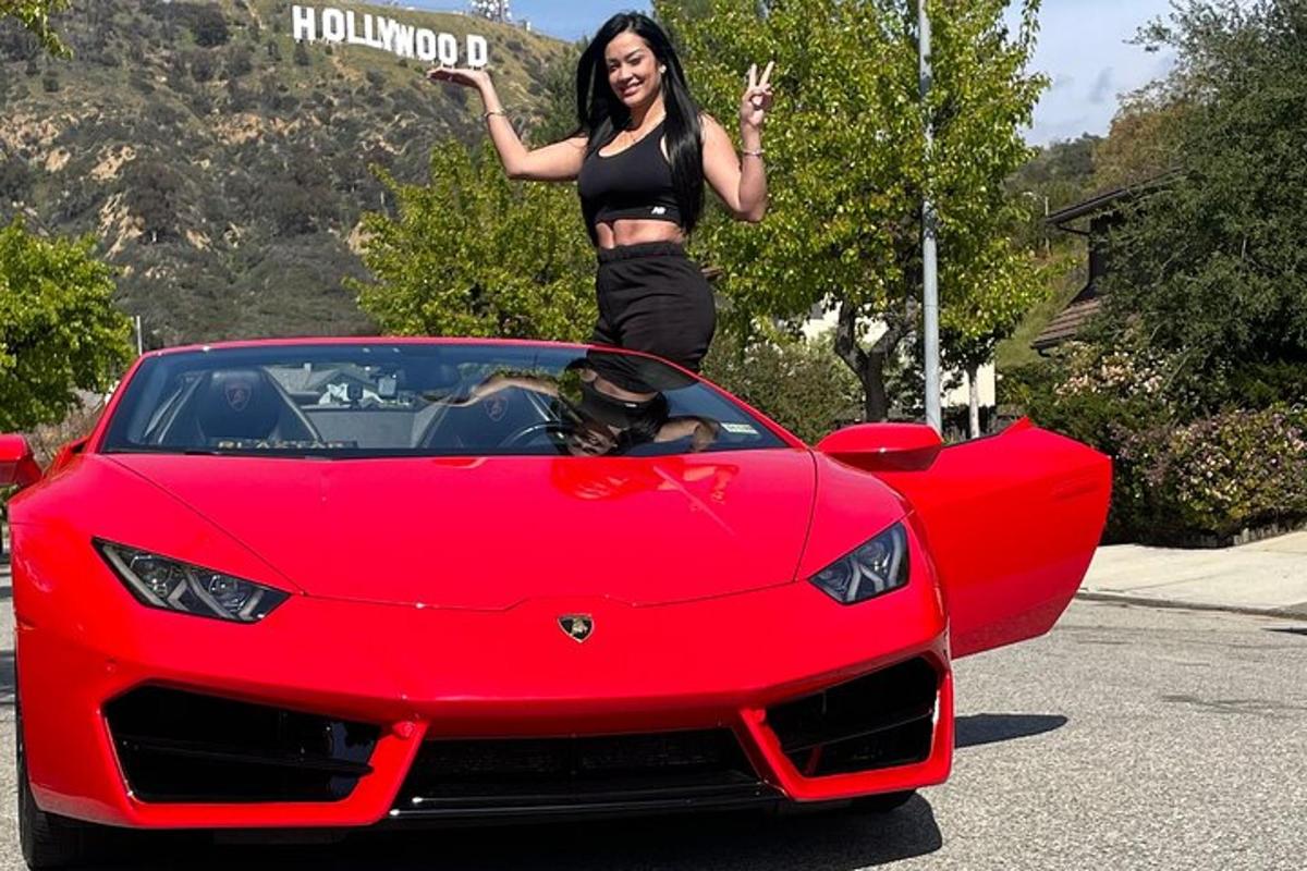 žena stojící na kapotě červeného Lamborghini