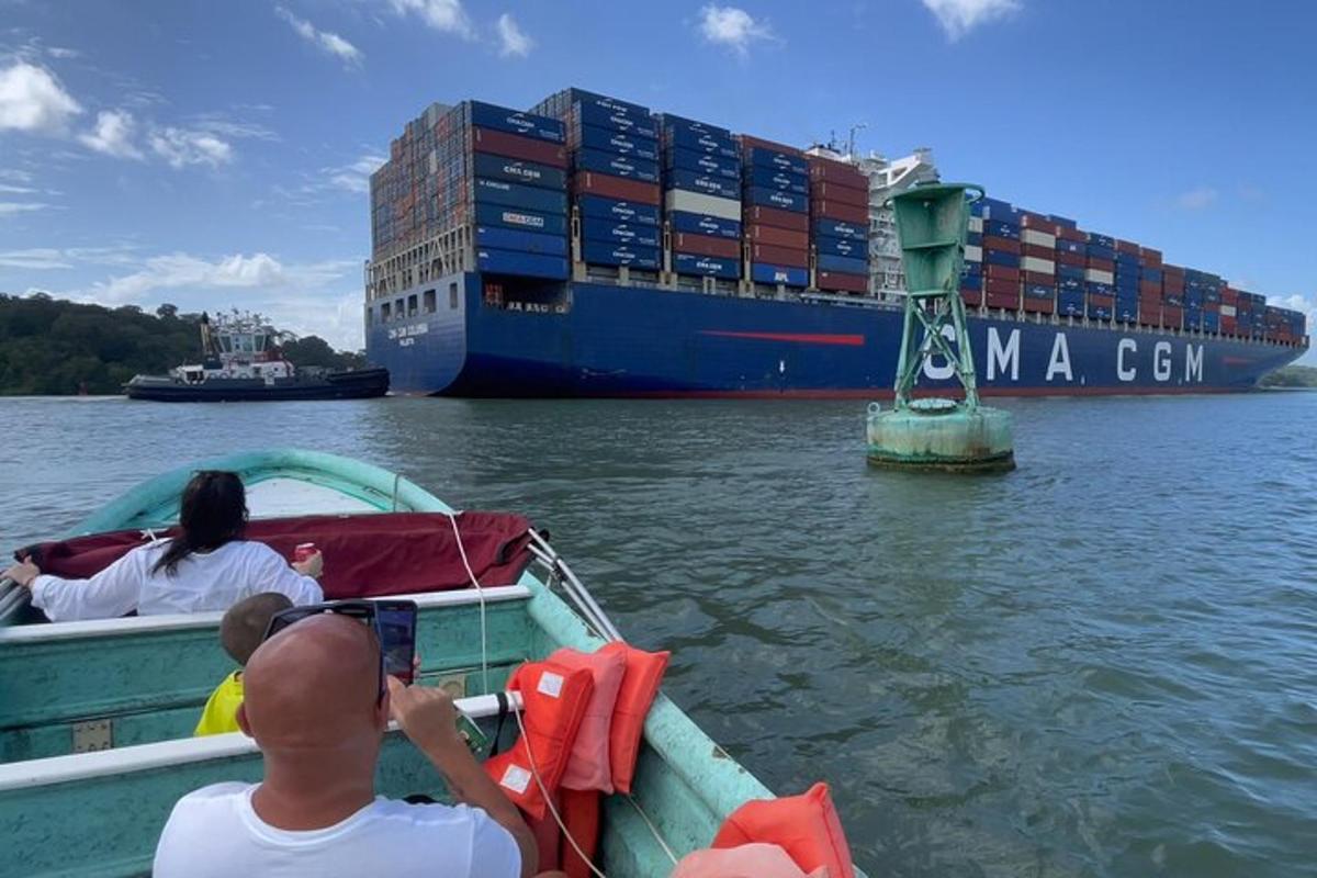 un uomo che scatta una foto di una nave portacontainer