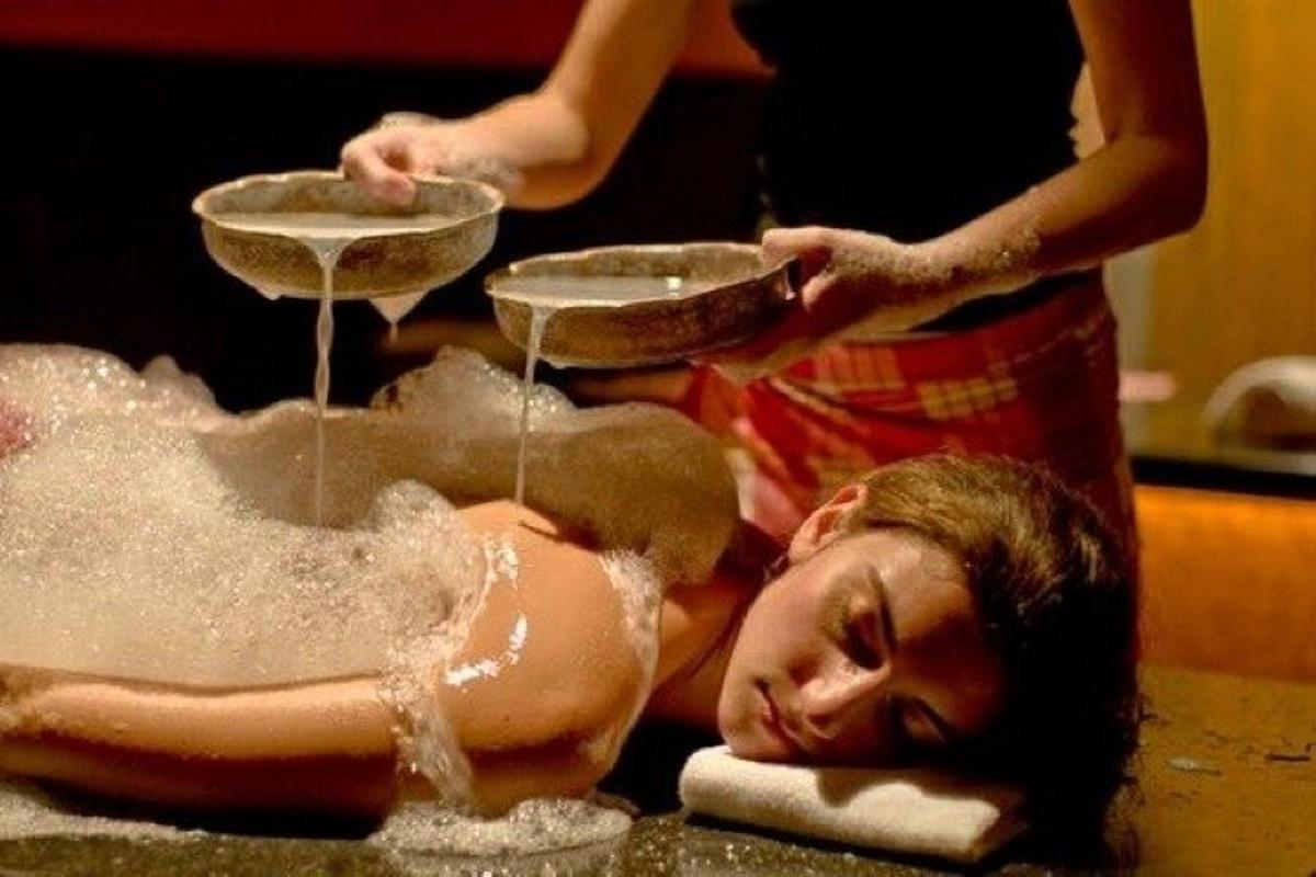 eine Frau, die in einer Badewanne liegt, aus der Wasser herauskommt