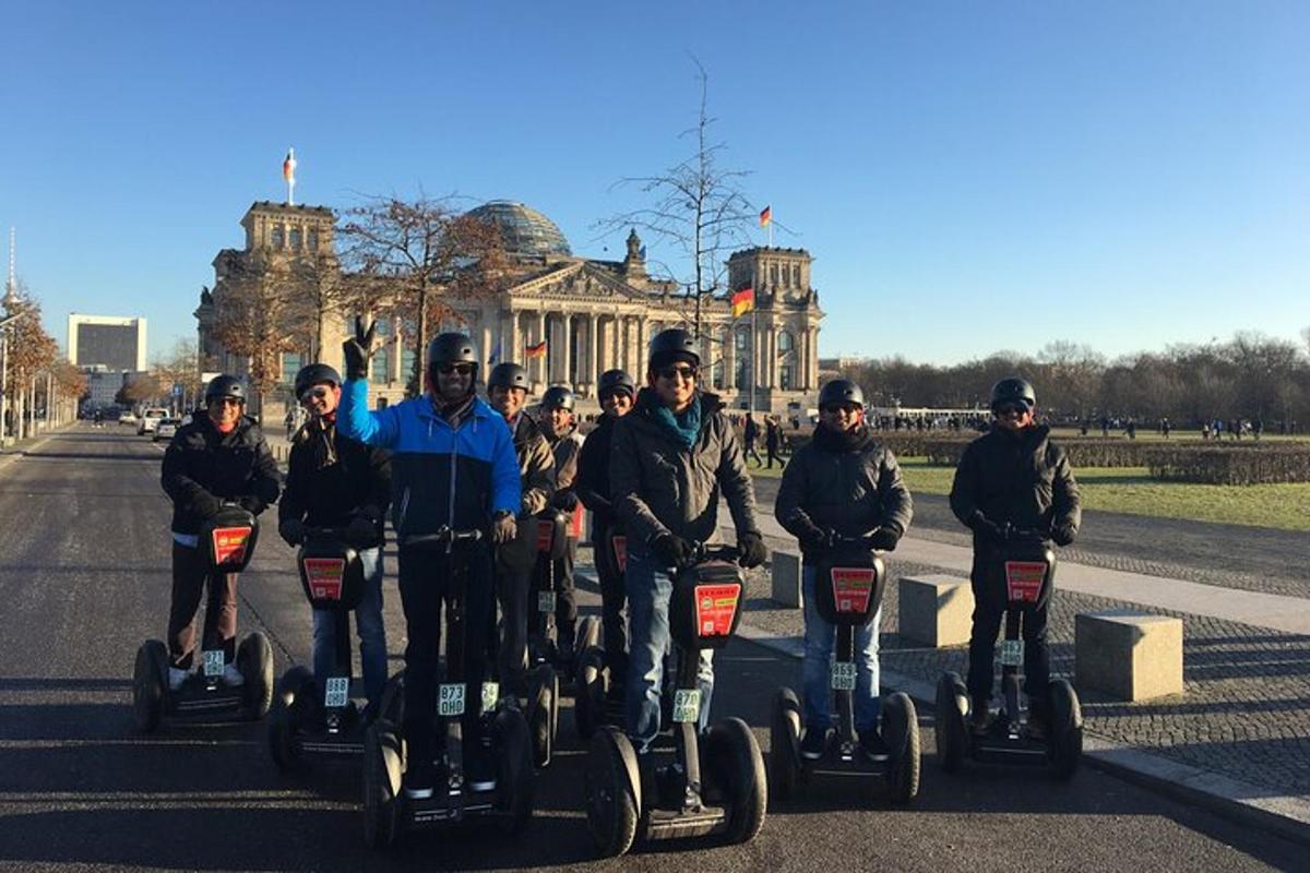 skupina lidí jedoucích na segwayích před budovou