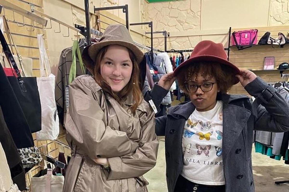 two women are wearing hats in a store