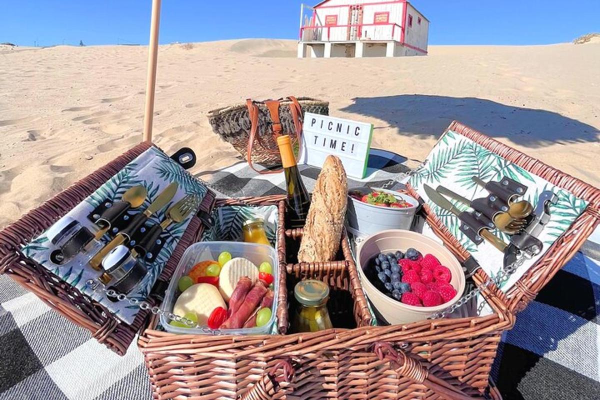 piknikkosár étellel egy takarón a strandon
