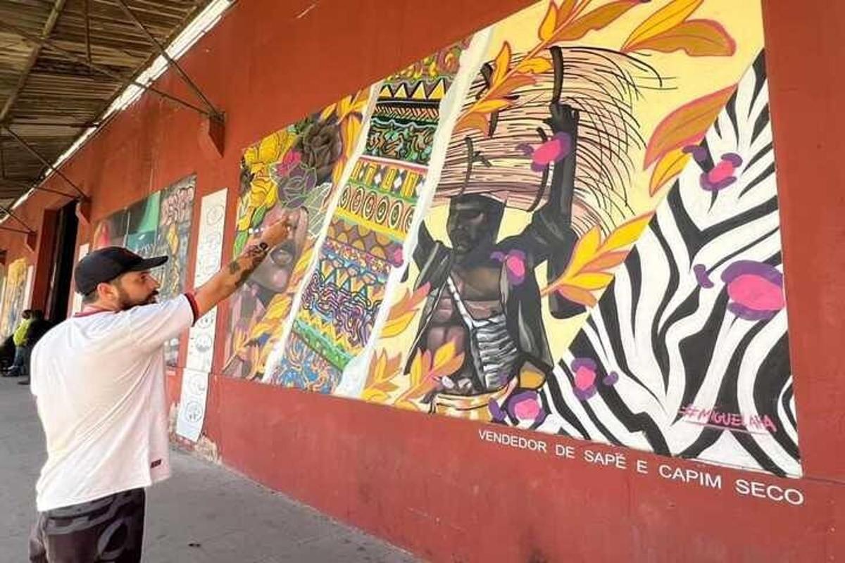 un home pintant un mural a la paret