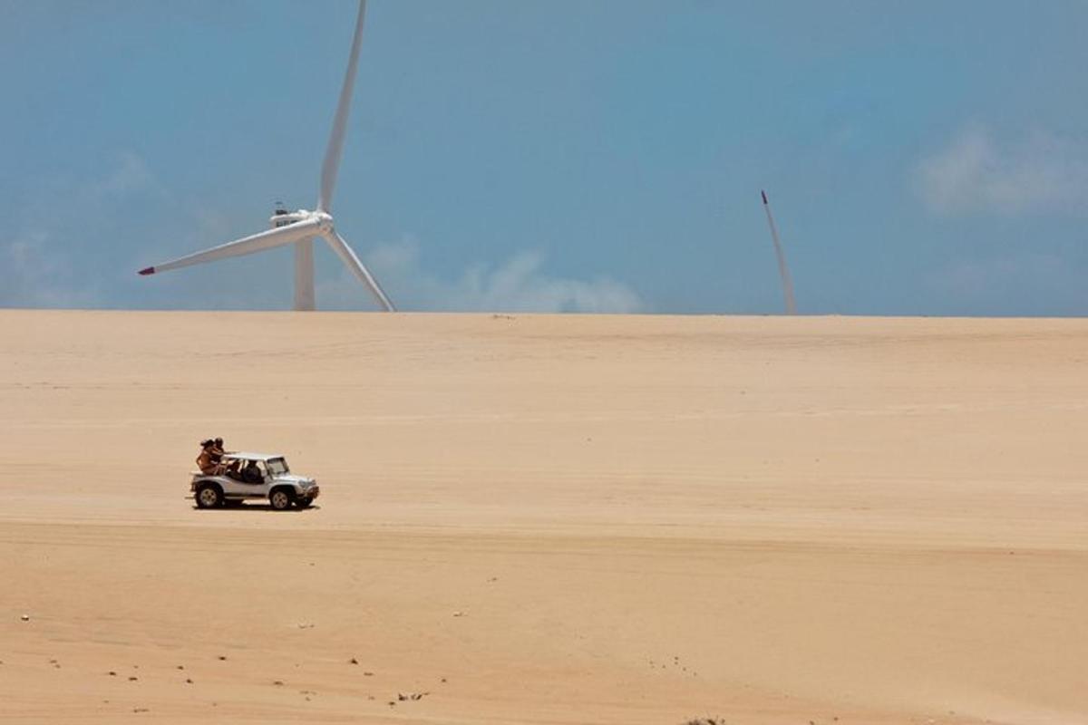 a person driving a toy car in the sand