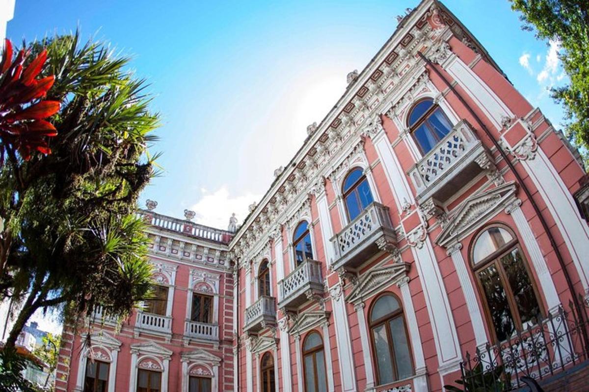 a pink building with a palm tree in front of it
