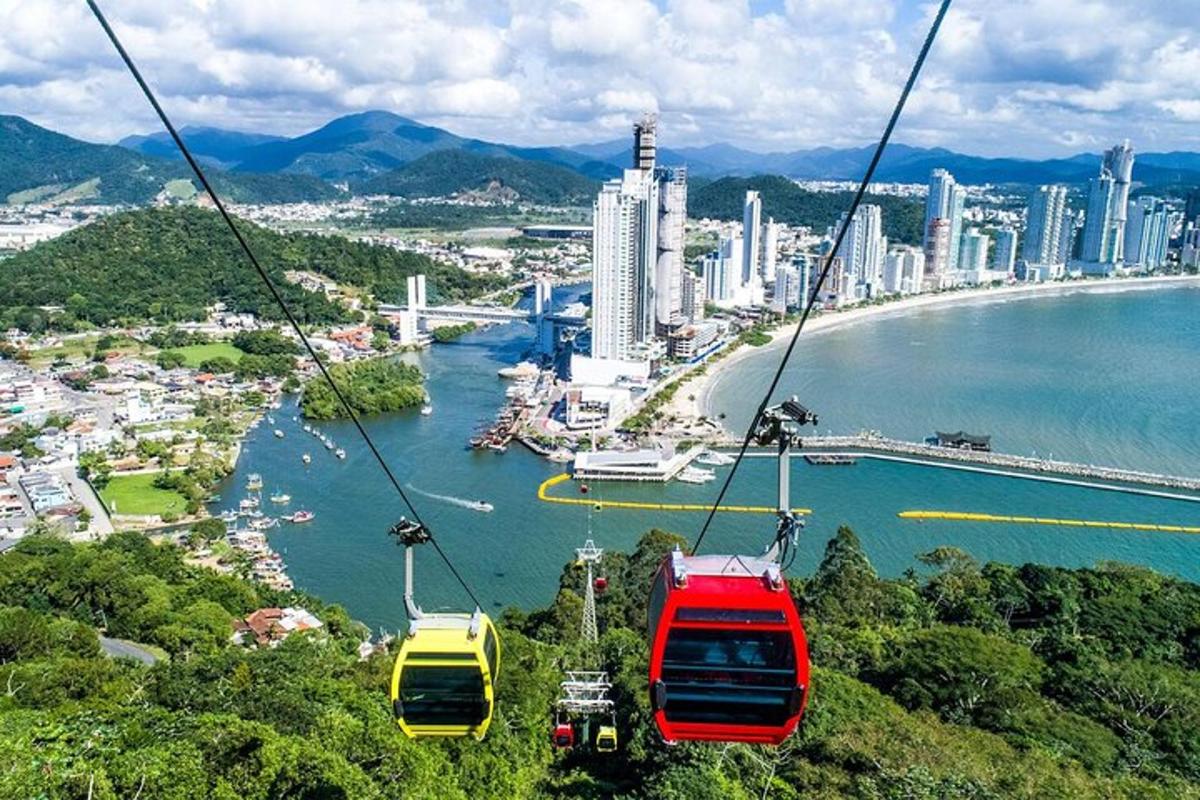 three gondolas on a cable car over a city