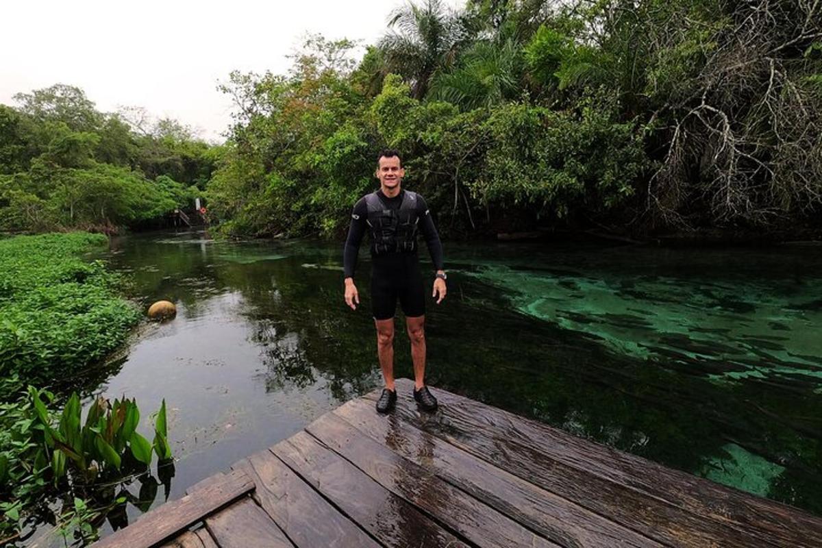 a man standing on a wooden bridge over a river