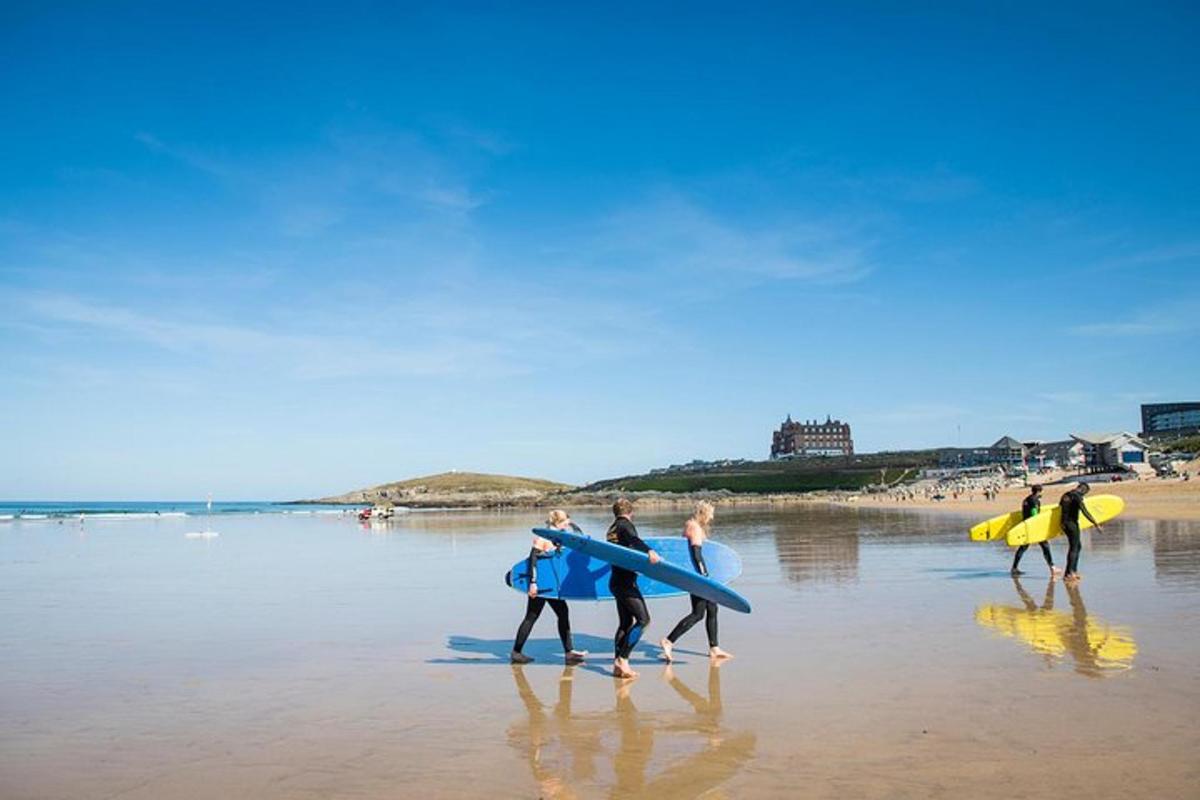 um grupo de pessoas caminhando na praia com pranchas de surfe
