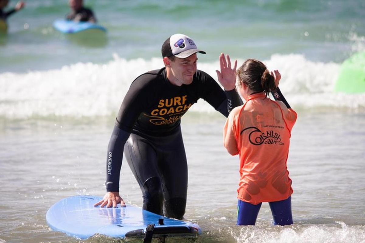 un uomo e una ragazza in piedi nell'oceano con una tavola da surf
