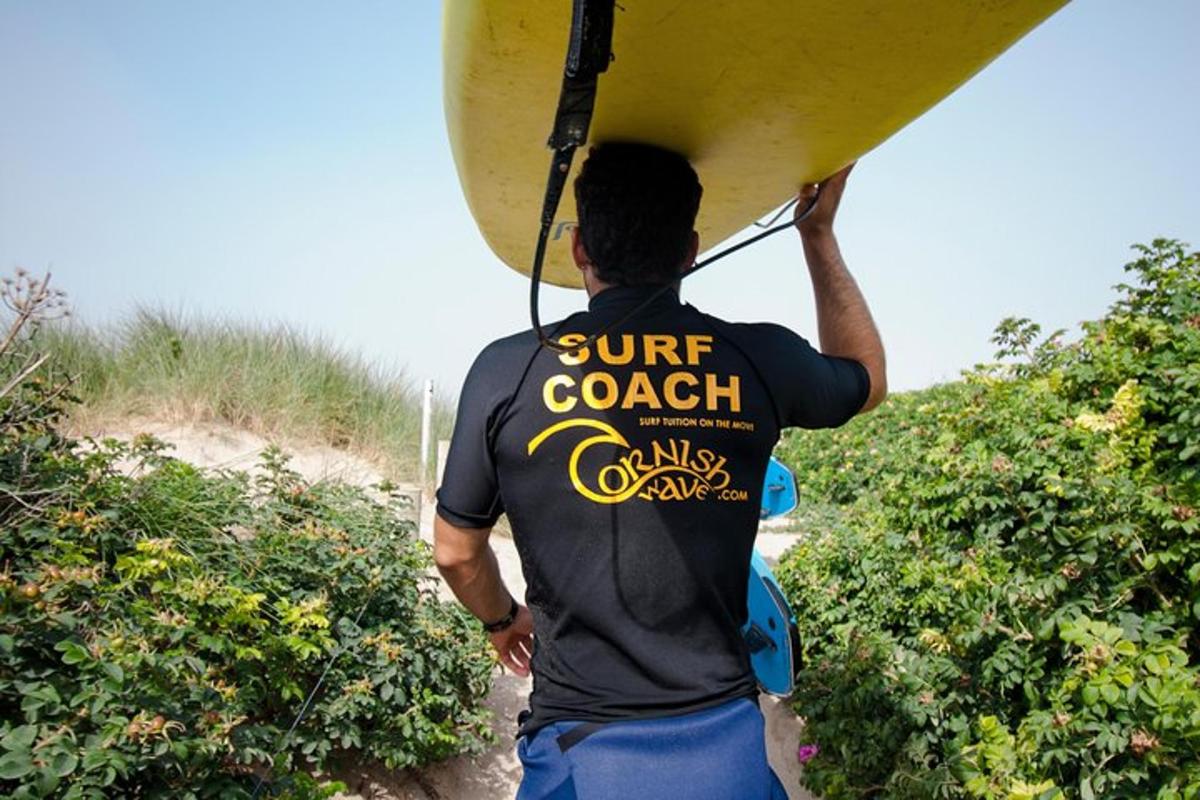 um homem carregando uma prancha de surfe nas costas
