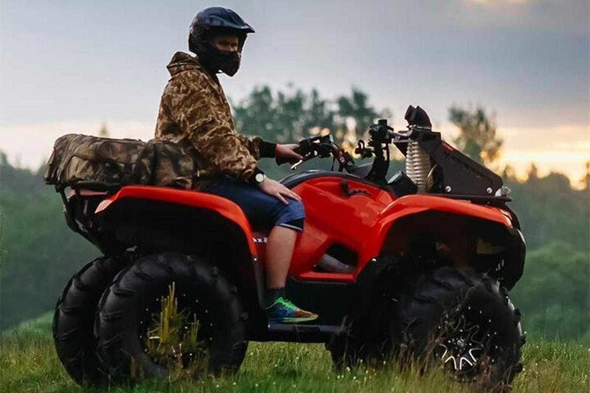 a man riding on a four wheeler in a field