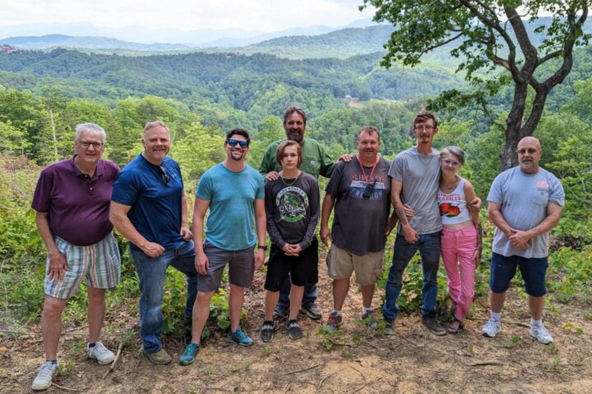 a group of people posing for a picture on a mountain