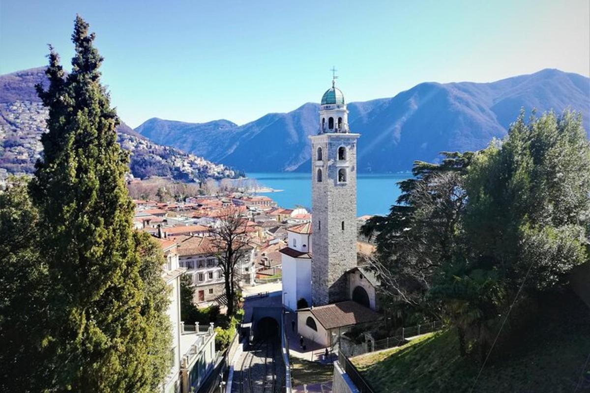 a tall white tower with a town and a lake