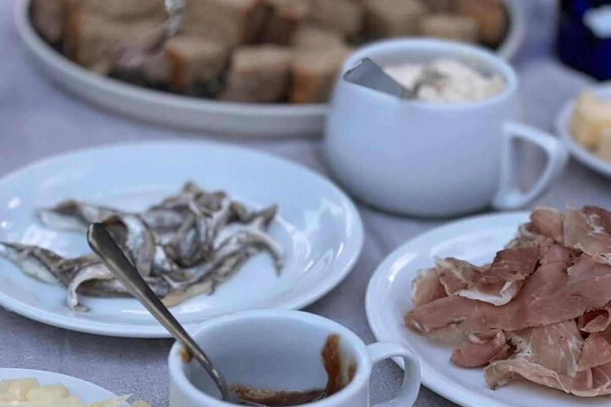 egy asztal húsos tányérokkal és kávéscsészékkel