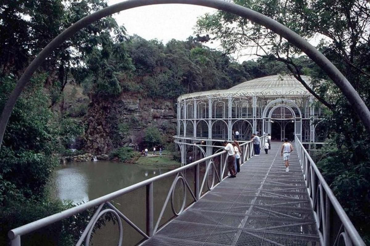 a group of people walking across a bridge over a pond