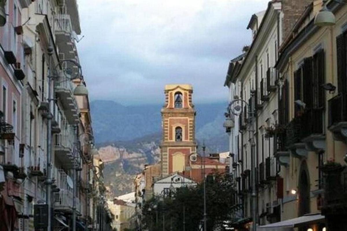ένα κτίριο με έναν πύργο ρολογιού στη μέση ενός δρόμου