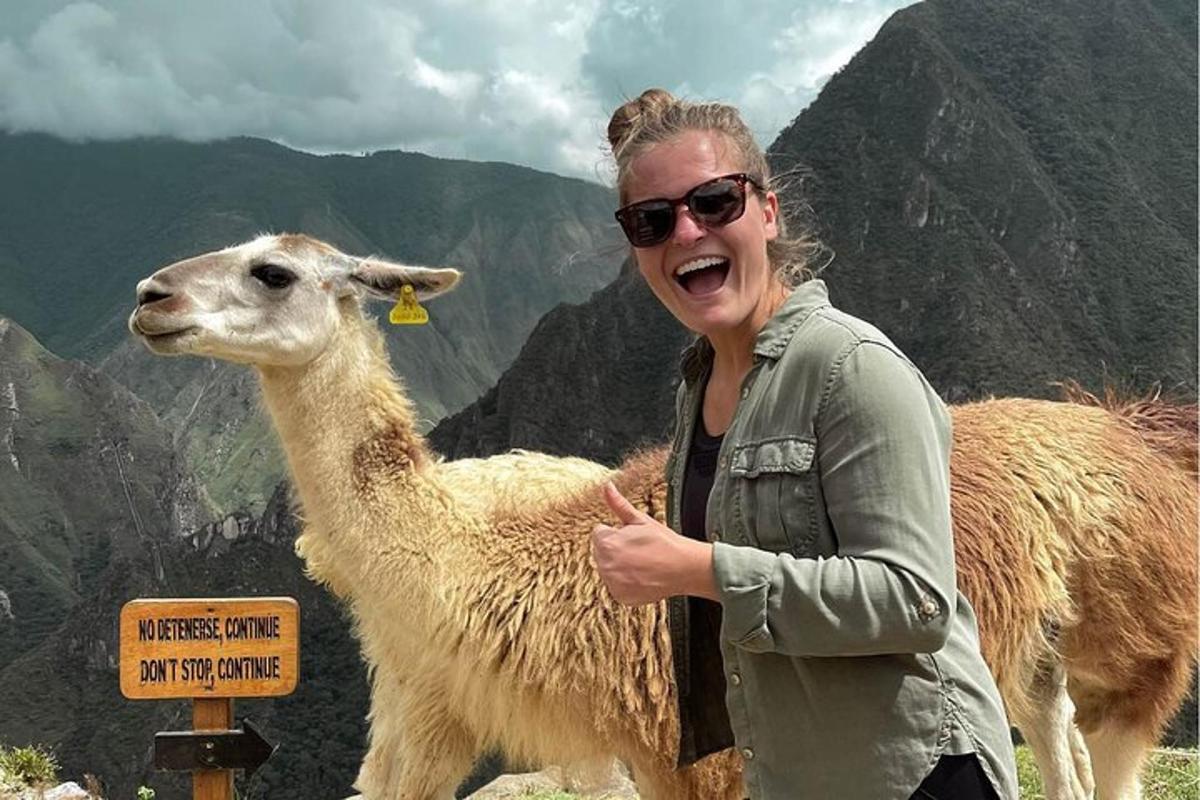 una donna in piedi accanto a un lama in montagna