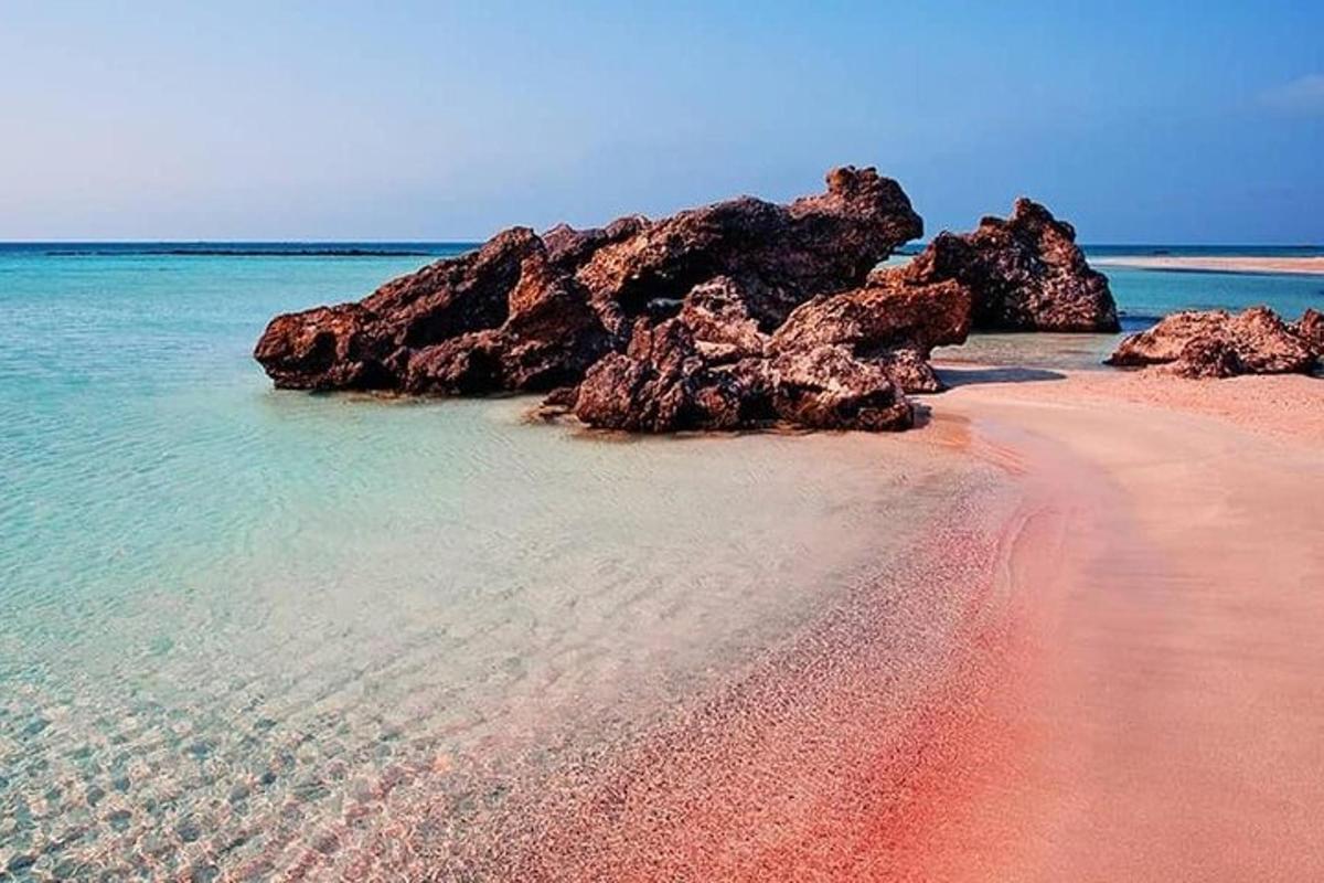μια παραλία με βράχια στο νερό και άμμο
