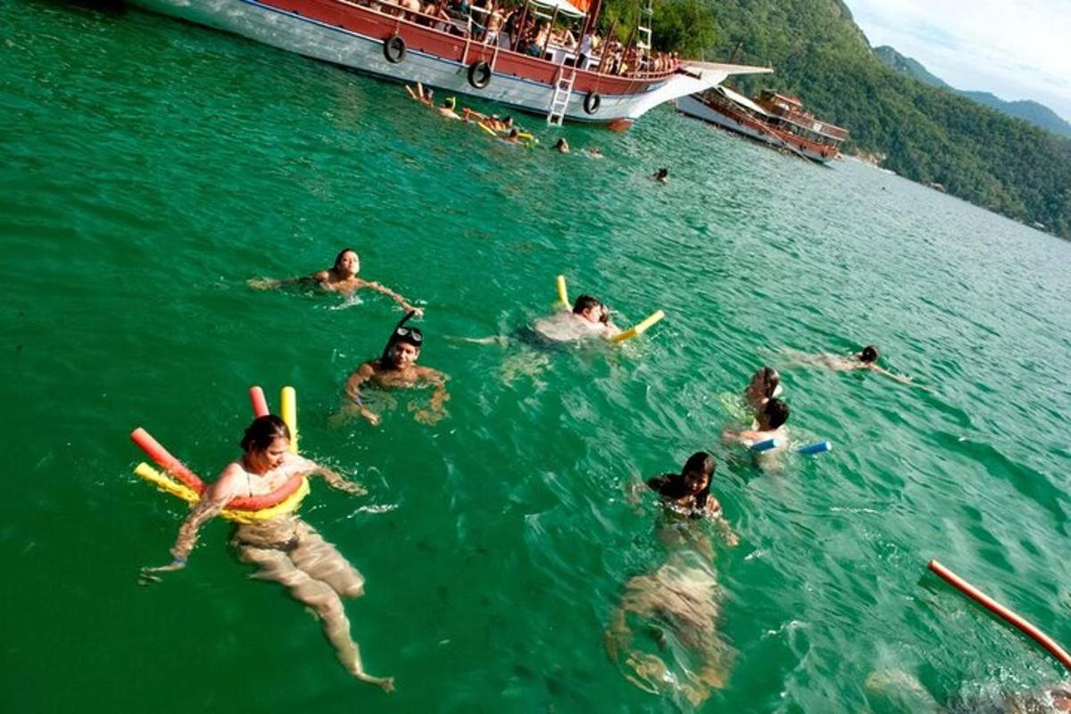 un gruppo di persone che nuotano nell'acqua vicino a una barca