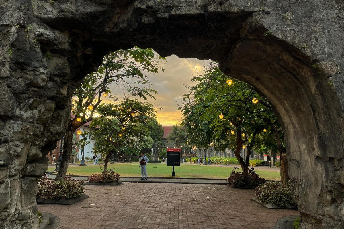 an archway in a park with a person walking through it