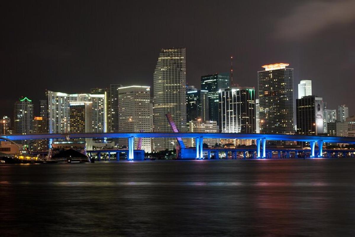 um horizonte de cidade à noite com uma ponte azul