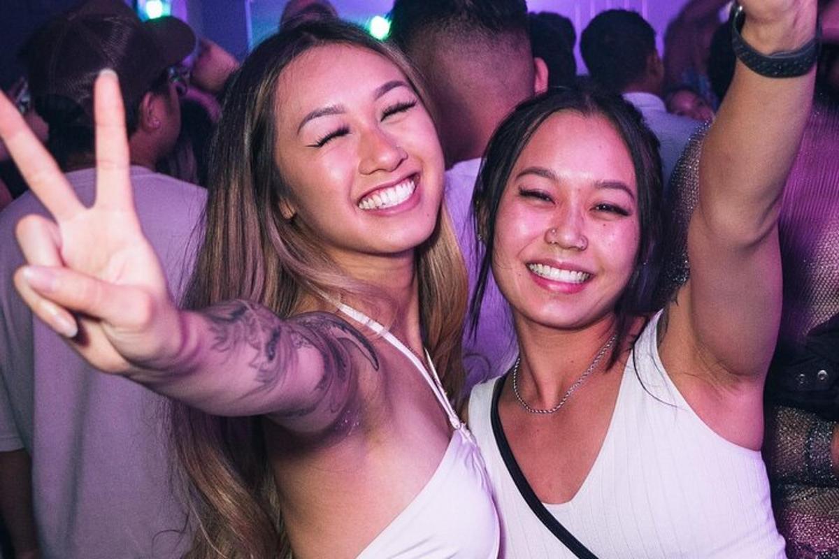 duas jovens fazendo o sinal da paz em uma festa