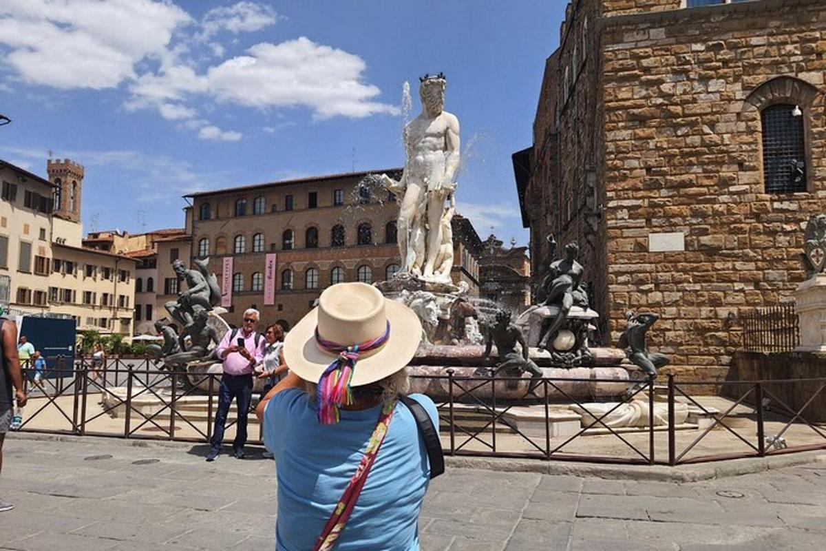 a woman in a hat standing in front of a statue