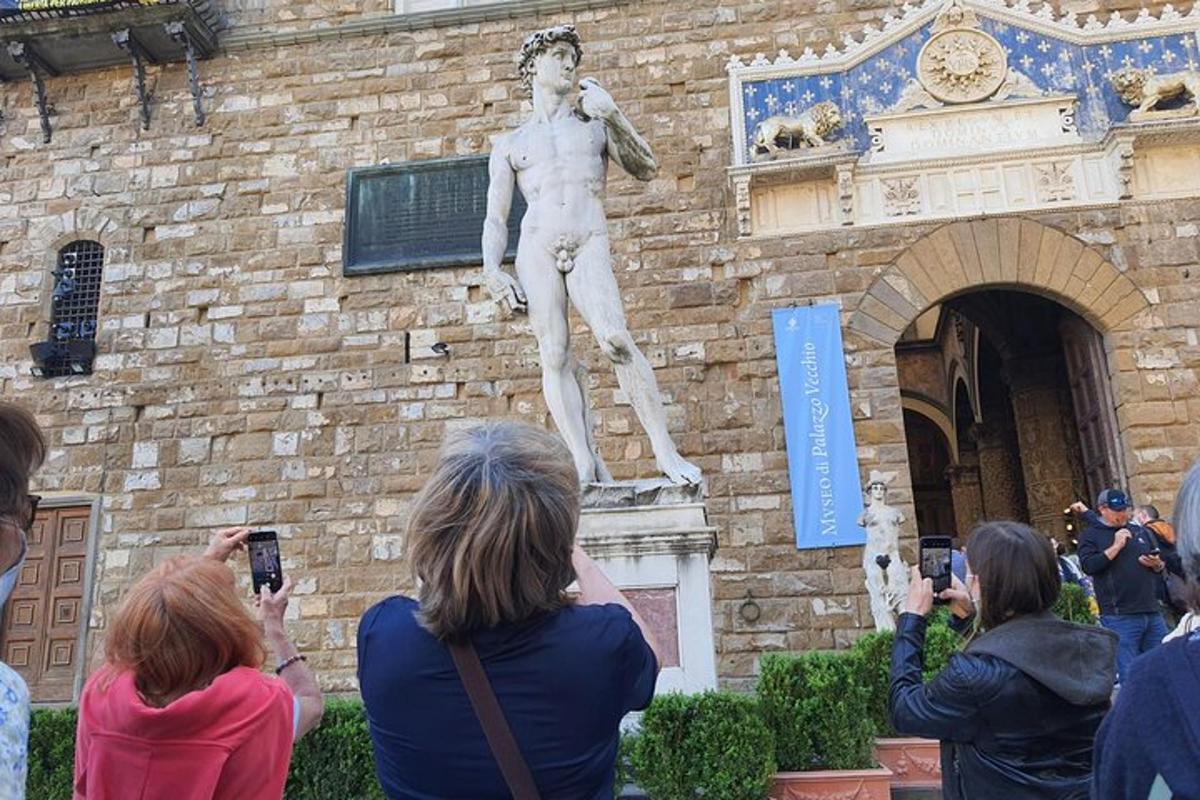 un grup de persones fent fotos d'una estàtua