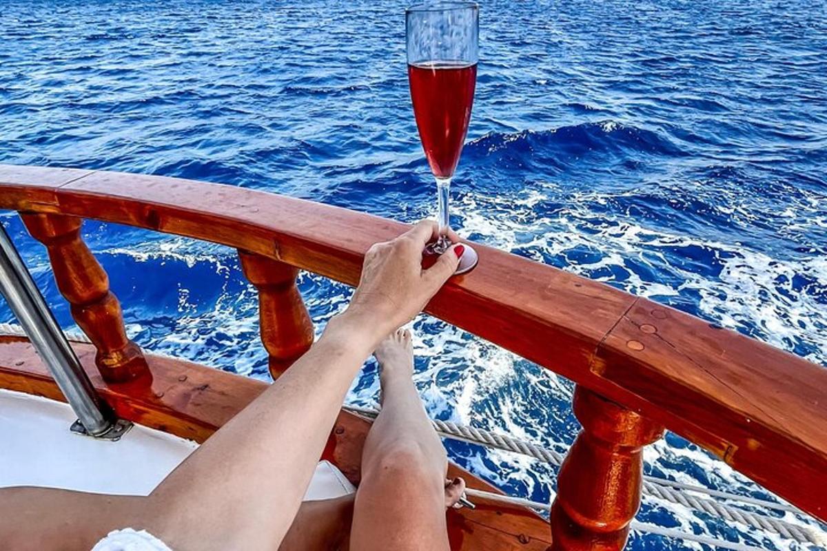een persoon die een glas wijn vasthoudt op een boot