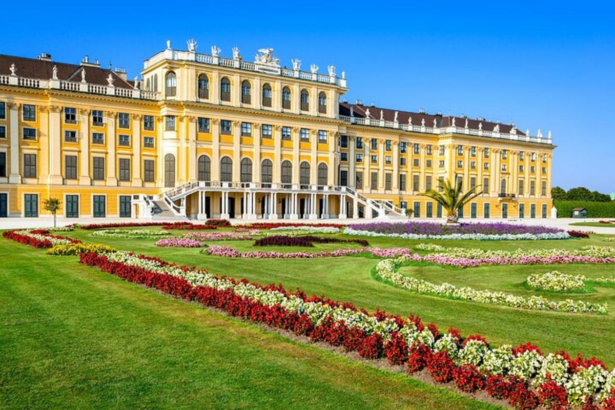 um grande edifício amarelo com um jardim na frente