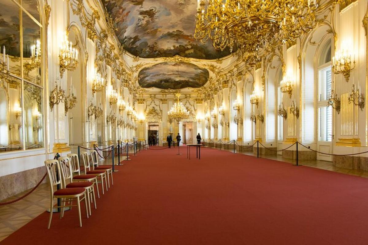 uma sala grande com tapete vermelho e lustres