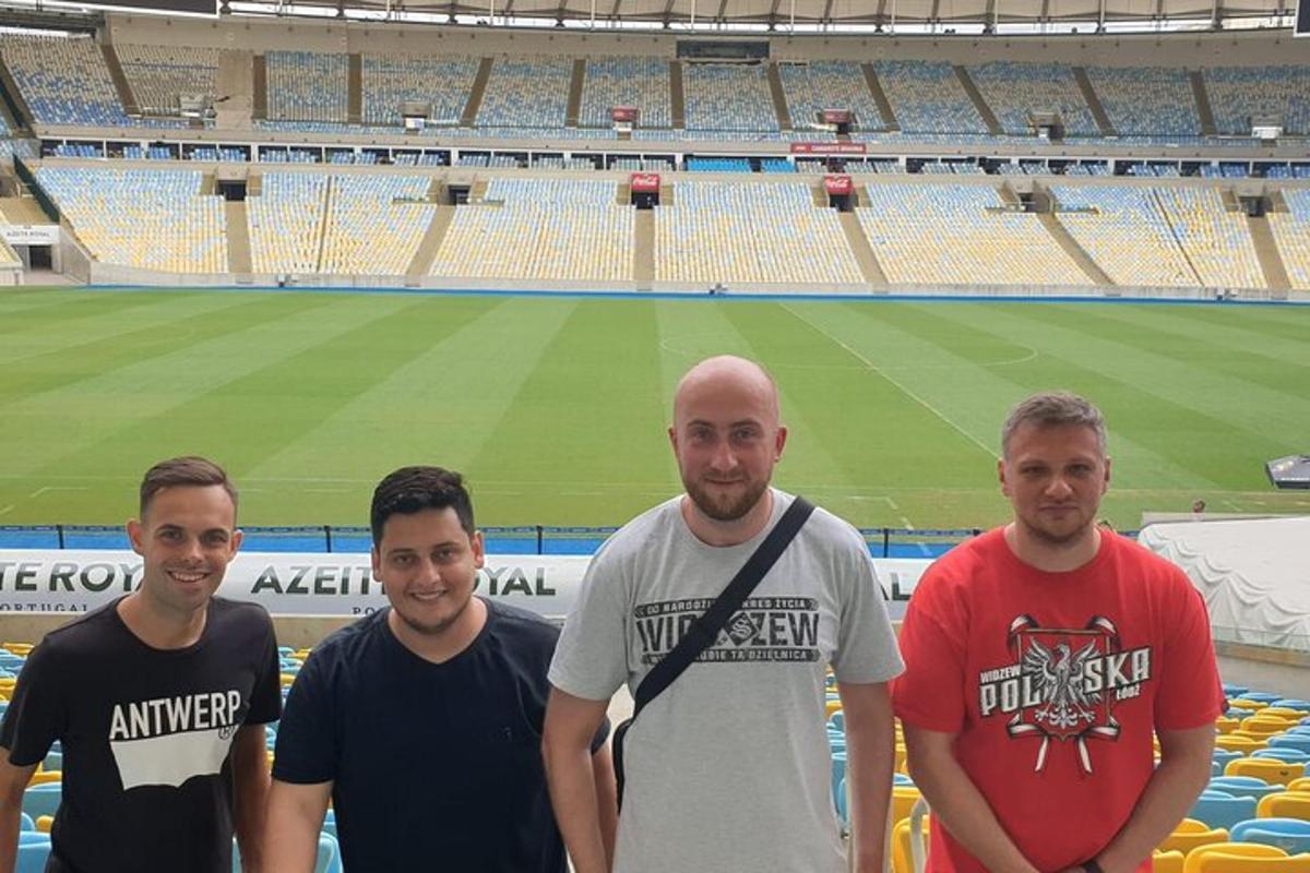 a group of men standing in front of a stadium
