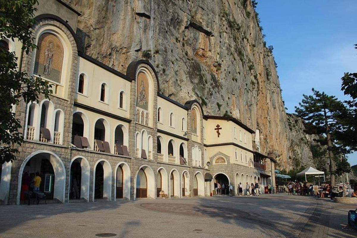 um edifício em frente a uma montanha ao lado de uma rua