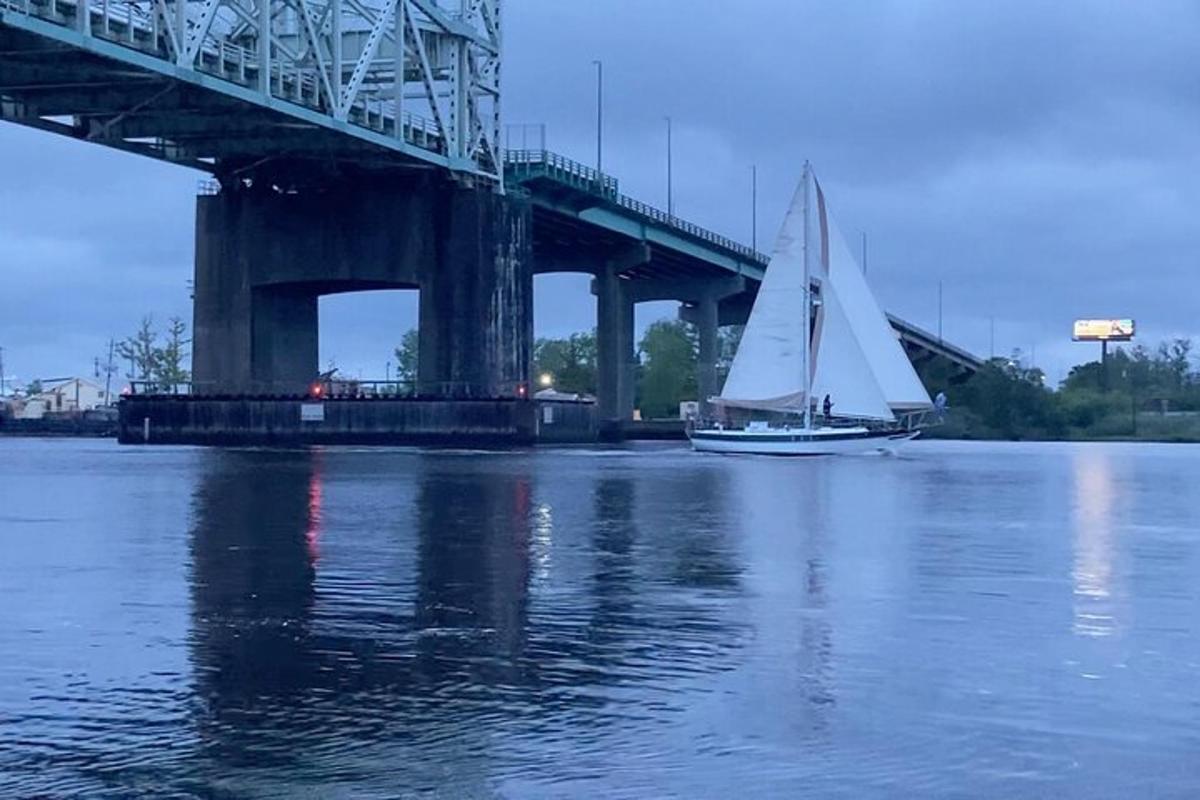 a sailboat on the water next to a bridge