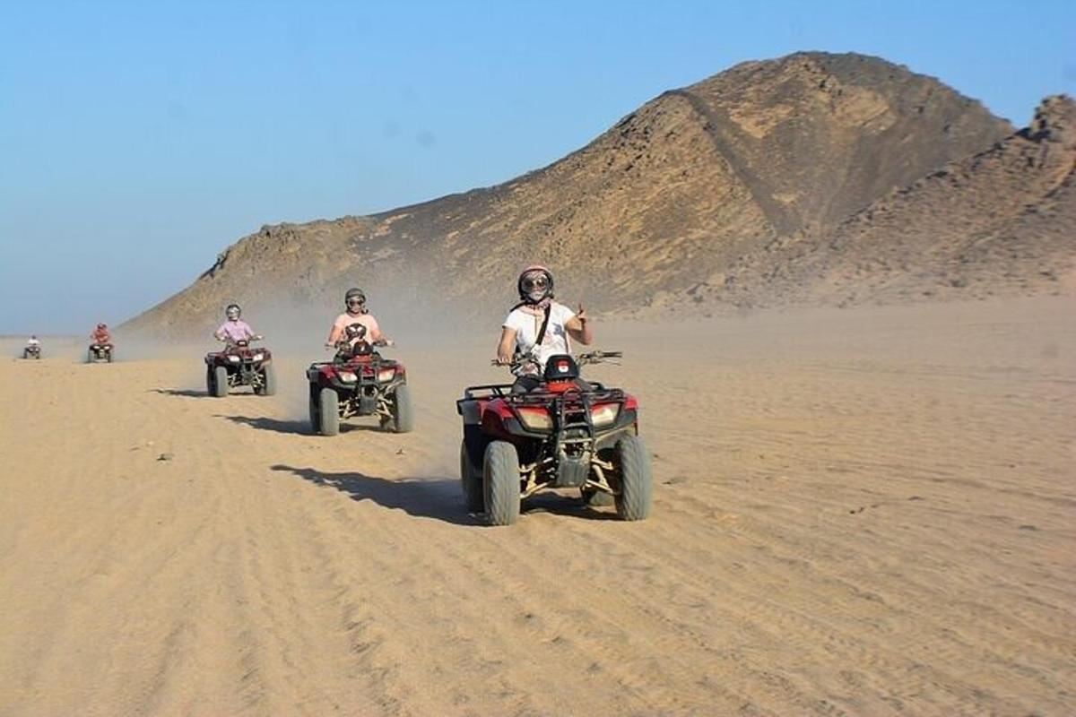 Un grupo de personas conduciendo vehículos todo terreno en el desierto.
