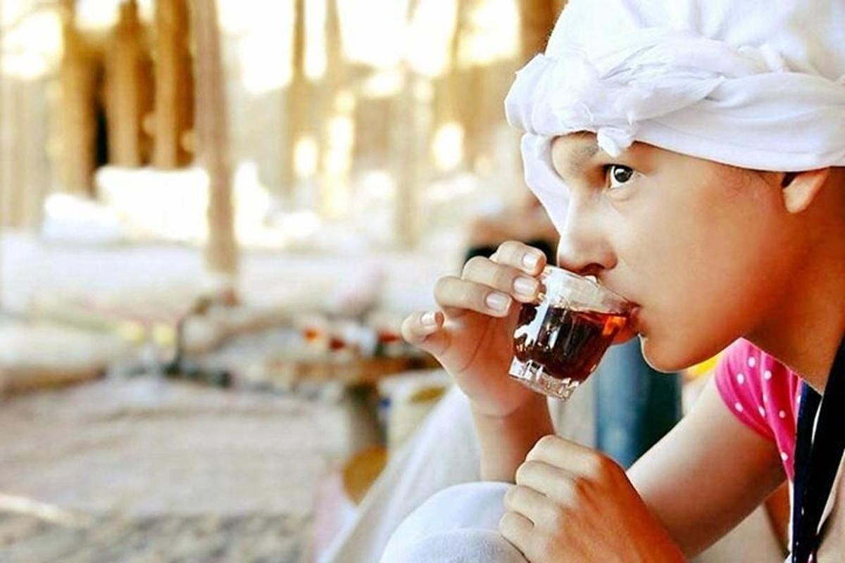 Una niña bebiendo una bebida de un vaso