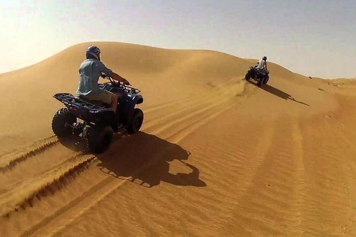 dalawang tao na nakasakay sa quad bike sa disyerto