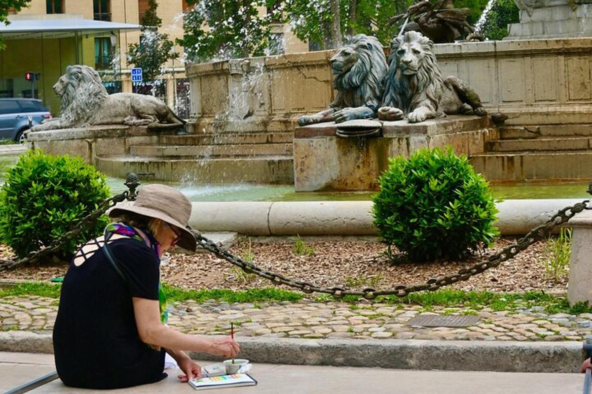 bir çeşmenin önünde yerde oturan bir kadın