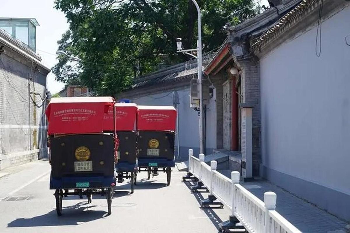 Două containere roșii sunt parcate lângă o clădire