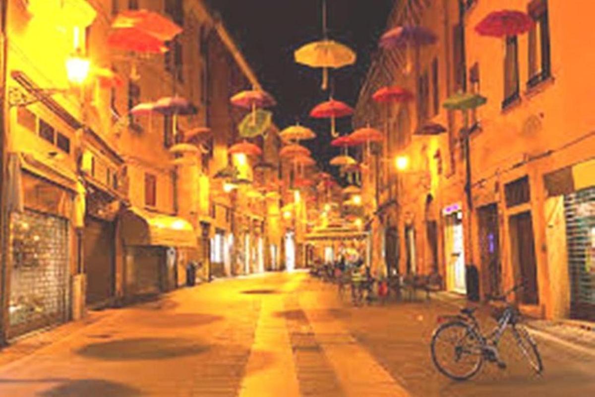 an alley with umbrellas hanging over a street at night