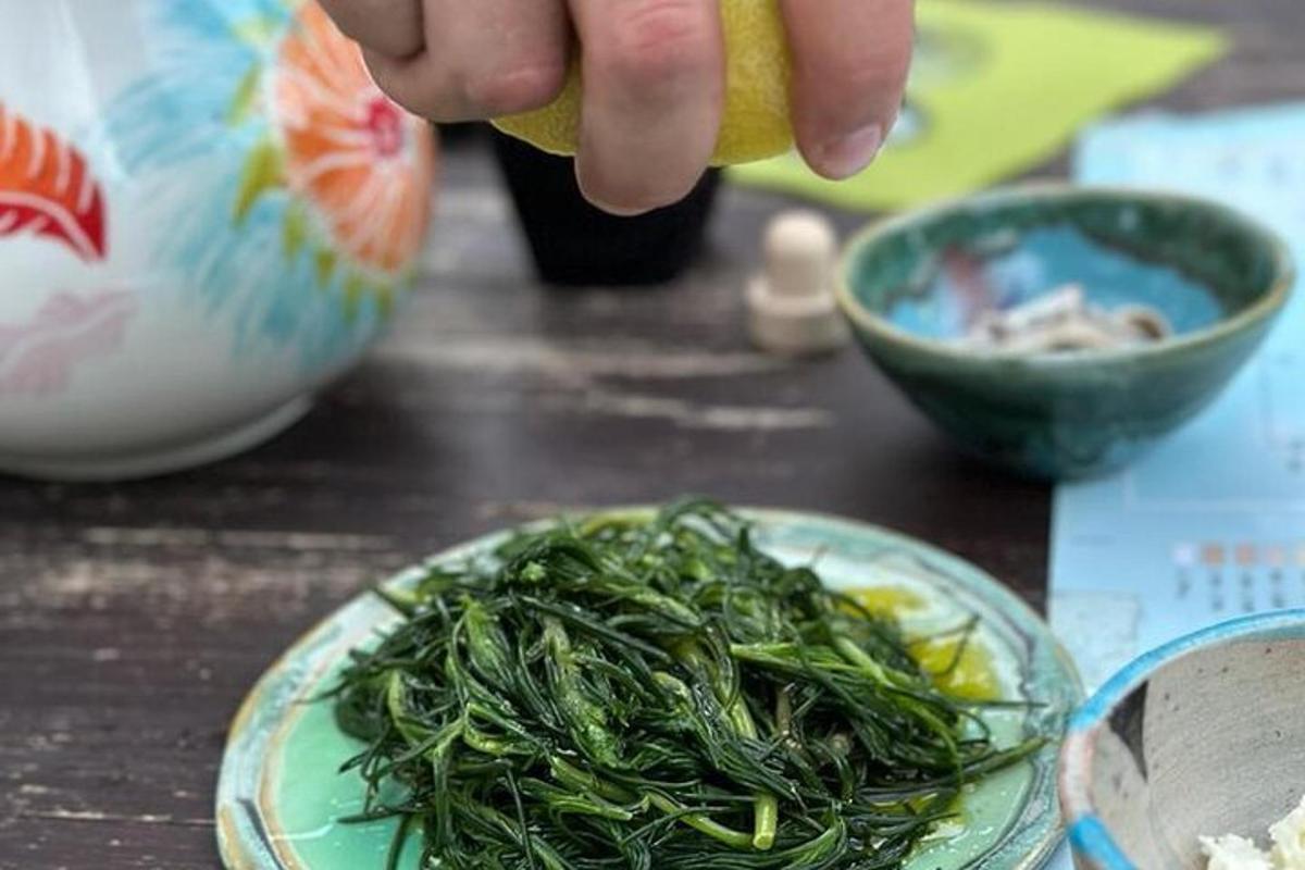 isang taong may hawak na lemon sa tabi ng isang plato ng pagkain