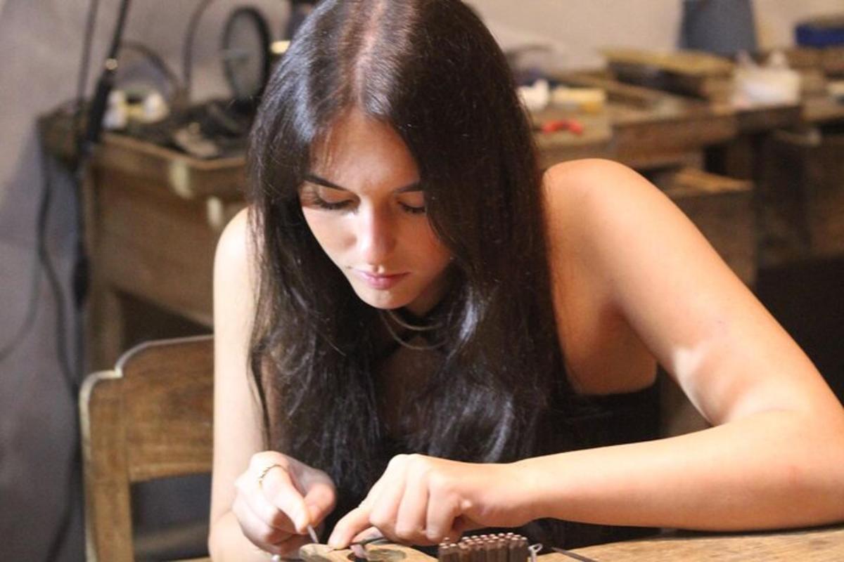 Μια γυναίκα που κάθεται σε ένα τραπέζι κοιτάζοντας ένα cupcake