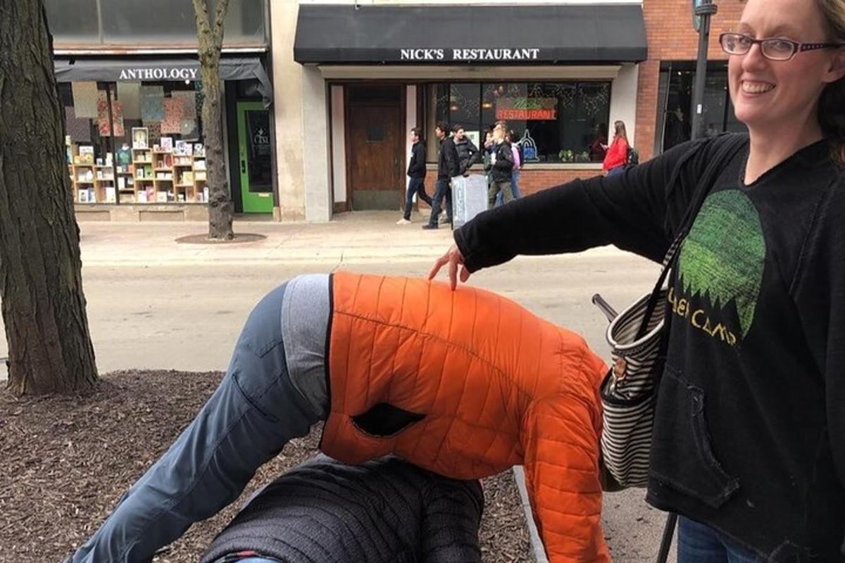 une femme se tient à côté d'un animal en peluche