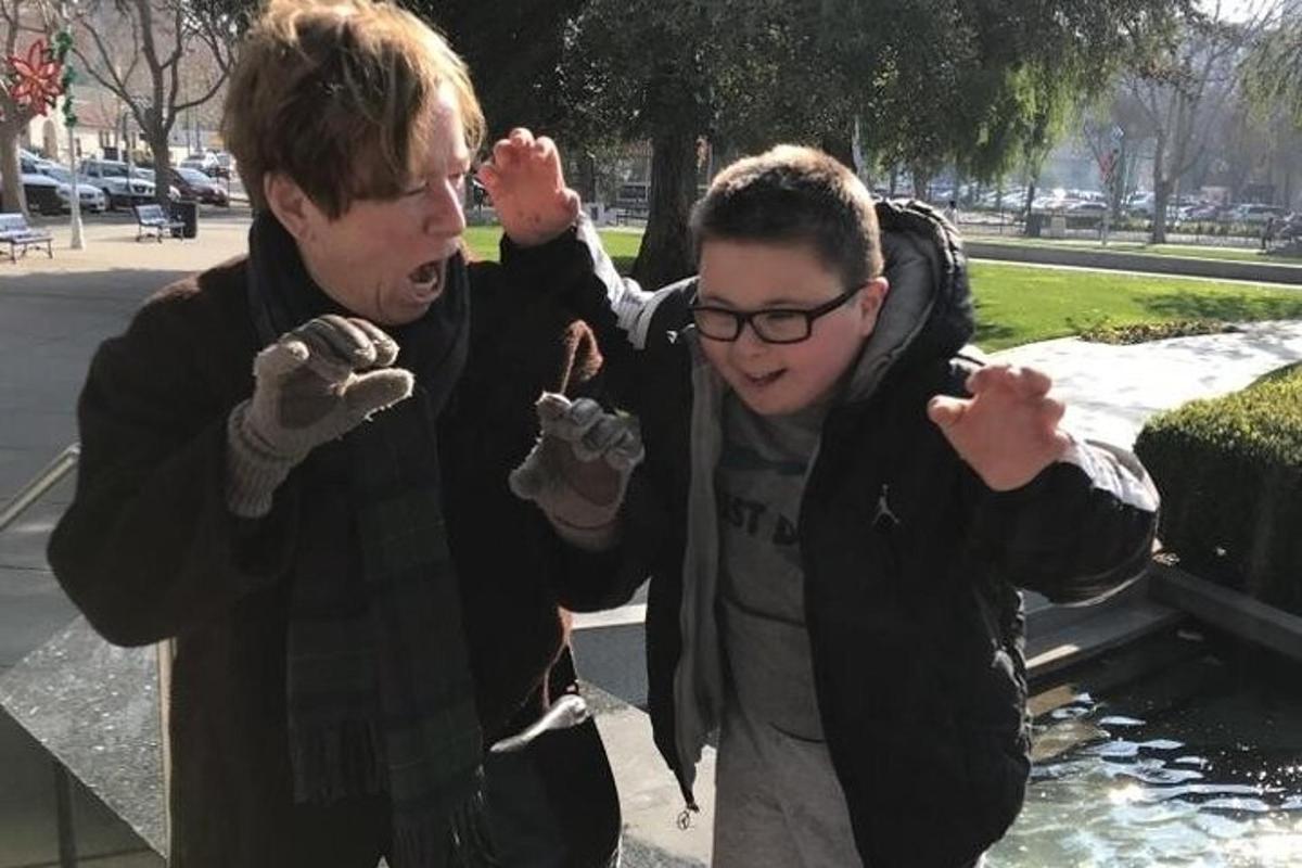 two young men eating donuts in a park