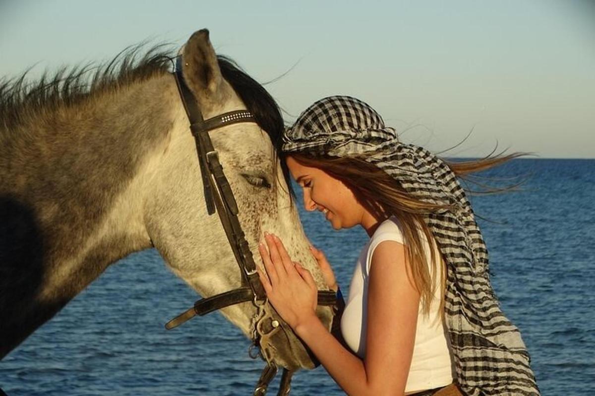 una donna è in piedi accanto a un cavallo