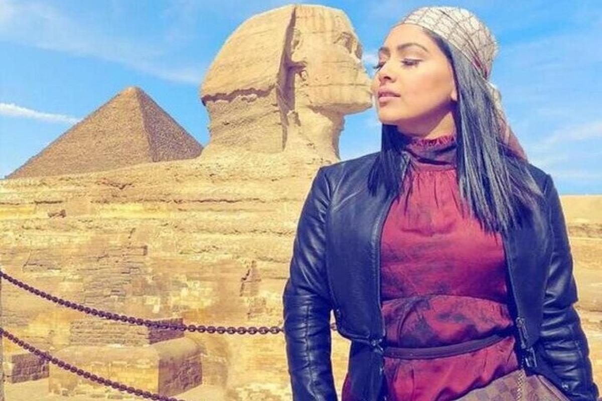 žena stojící před pyramidami