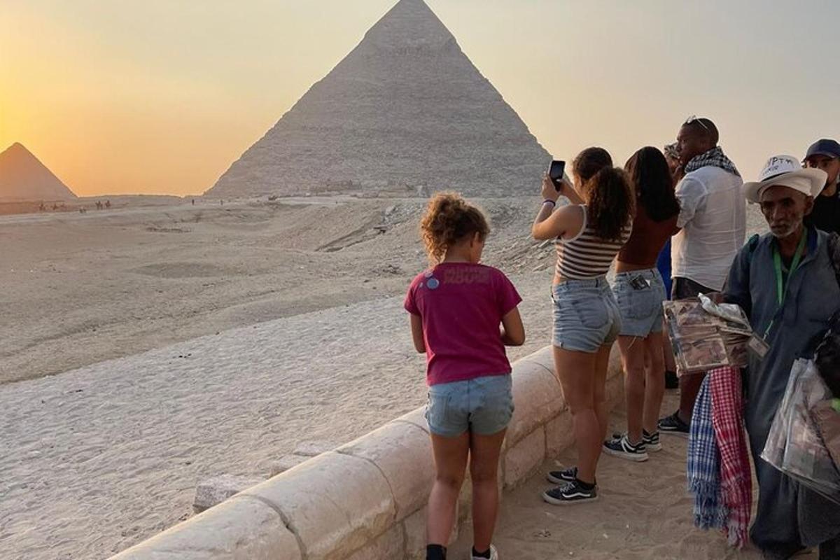 um grupo de pessoas em pé em frente às pirâmides