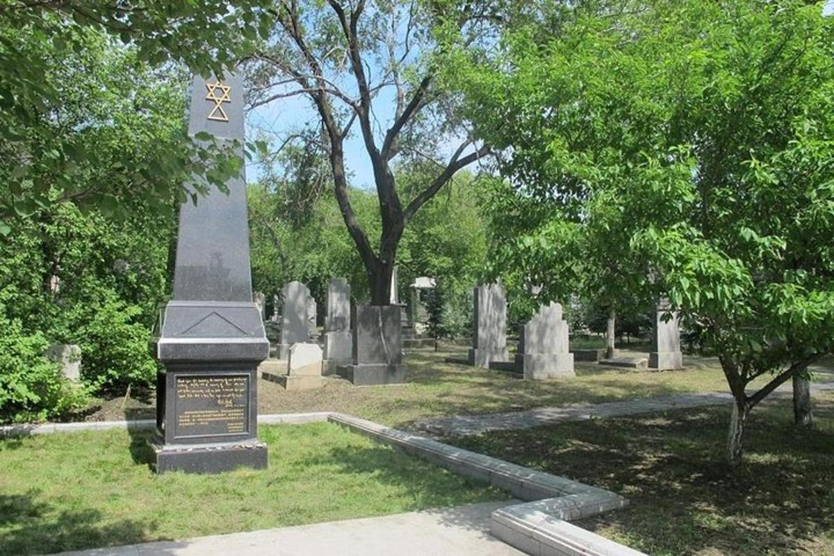 a monument in a cemetery with trees in the background