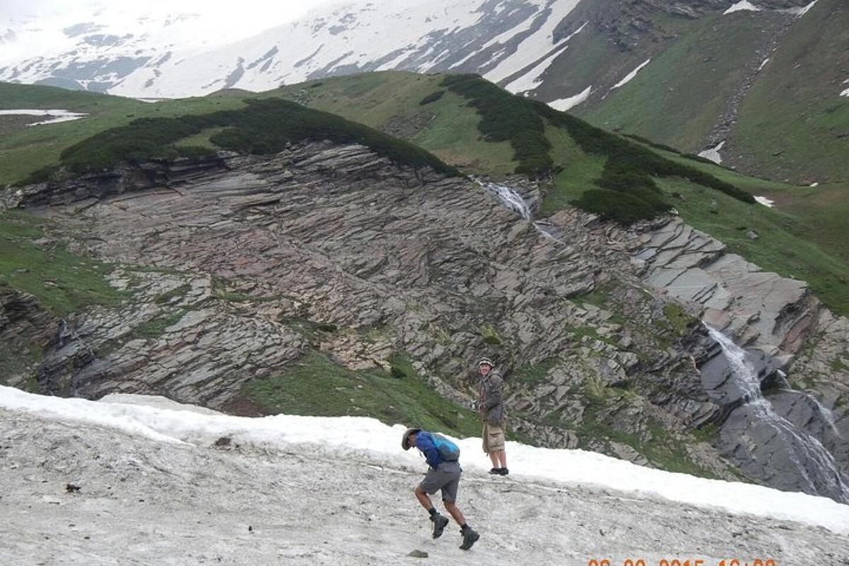two people standing on top of a snow covered mountain