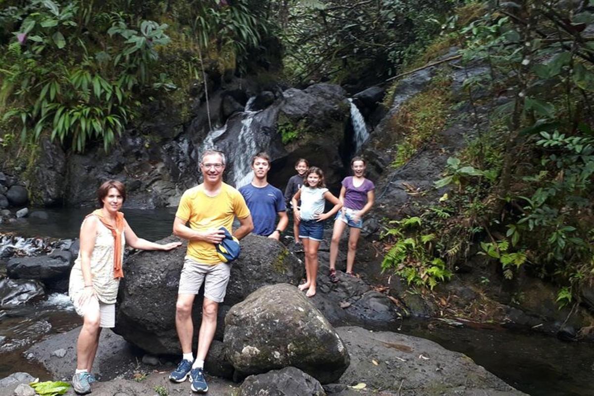 a group of people standing on rocks near a waterfall